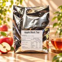 Apple Black Tea in a silver foil package containing 60 tea bags of 10g each, displayed with whole and sliced red apples and a glass cup of brewed black tea.