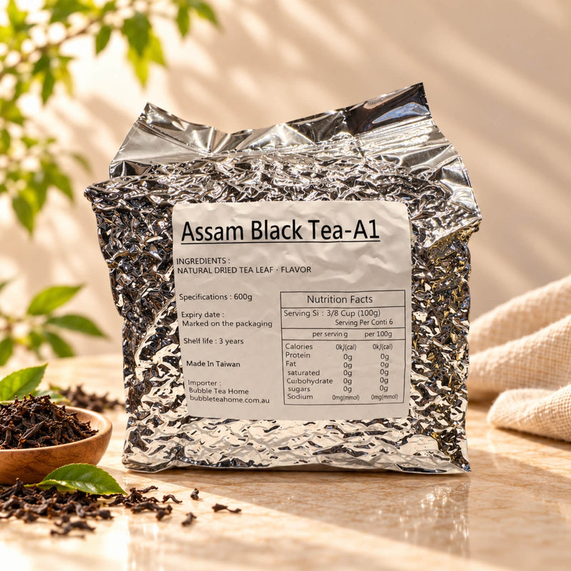 600g package of Assam Black Tea A1 in a silver foil bag with a product label, displayed alongside loose black tea leaves.