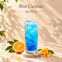 Blue Curacao sparkling drink made with blue curacao flavoured syrup, served over ice in a tall glass and displayed alongside fresh oranges.