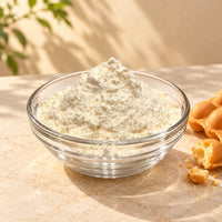 Bubble Waffle Powder piled in a clear glass bowl, showing its pale cream colour and fine texture, with freshly baked egg waffles beside it.