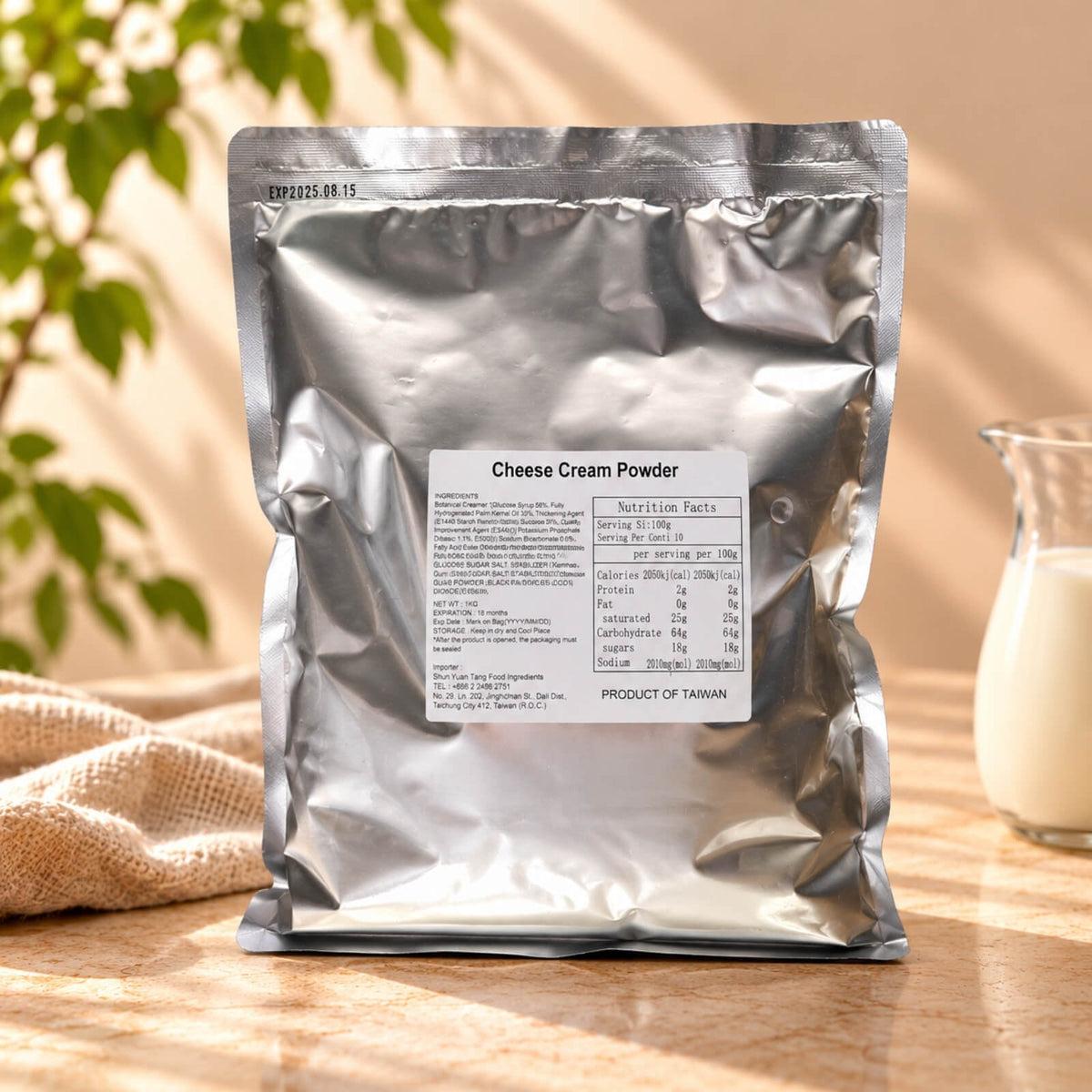 Cheese Milk Foam Powder in a 1kg silver foil package with a Cheese Cream Powder label, displayed alongside a glass jug of milk on a warm beige background.