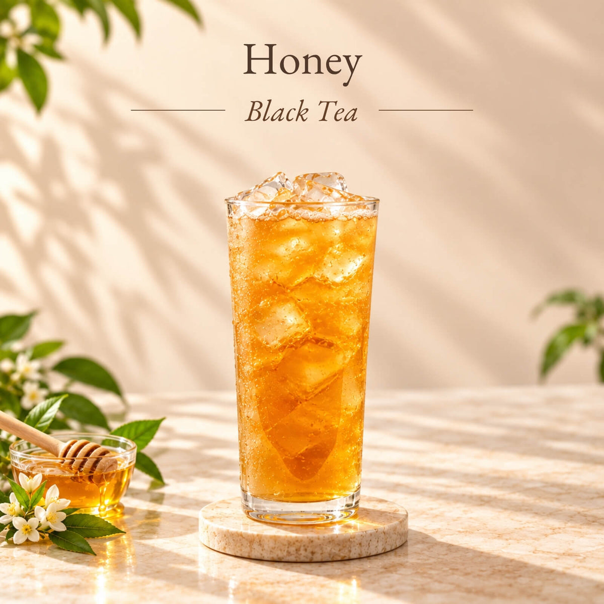 Iced honey black tea made with honey flavoured syrup, served in a tall glass with ice and displayed alongside a bowl of honey and a wooden honey dipper.