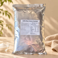 1kg Non-Dairy Creamer Powder in a silver foil package labelled Non-Dairy Creamer, displayed with a small bowl of white creamer powder on a warm beige background.
