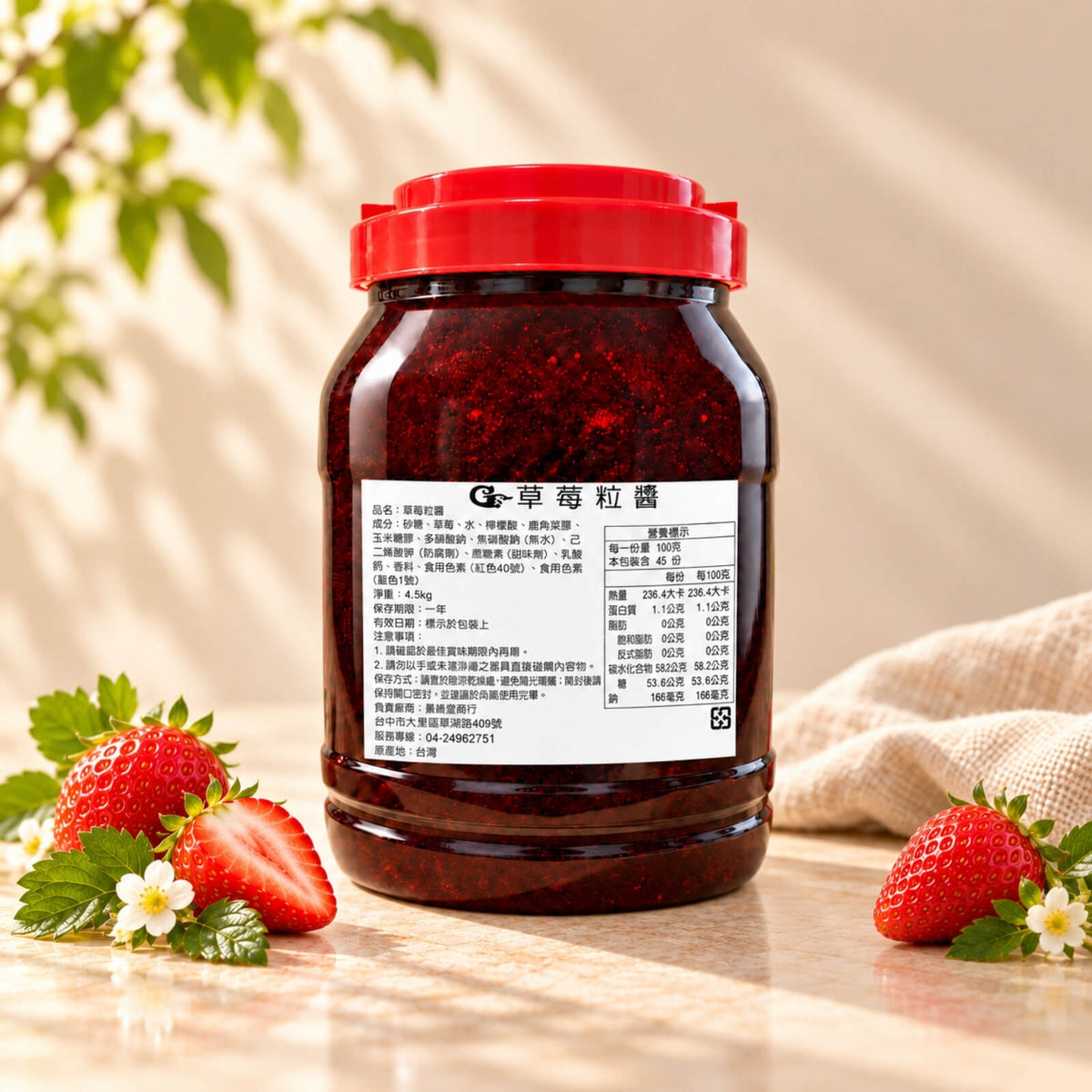 4.5kg tub of Strawberry Jam with a red lid, showing its deep red colour and visible fruit pieces, displayed alongside fresh strawberries.