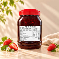 4.5kg tub of Strawberry Jam with a red lid, showing its deep red colour and visible fruit pieces, displayed alongside fresh strawberries.